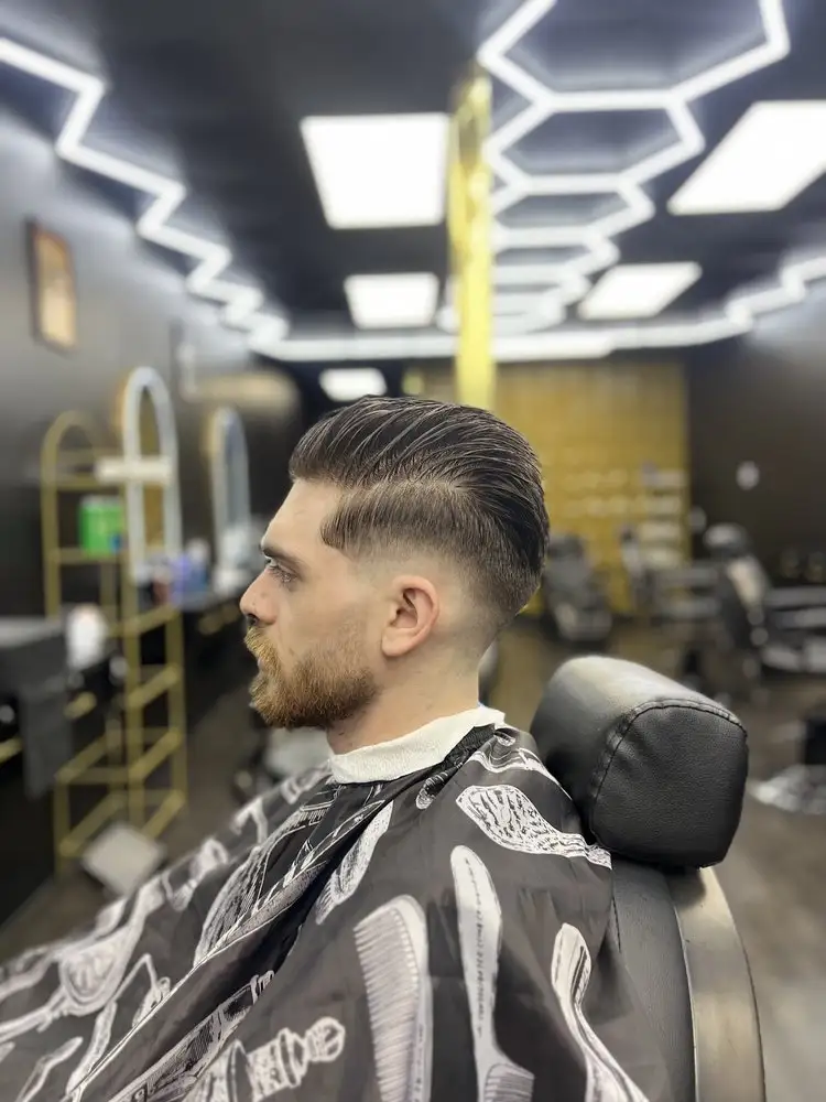 A slicked-back cut with a skin fade, side view