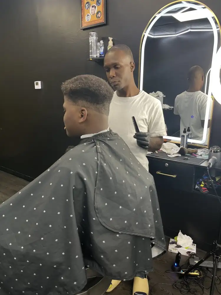 A barber finishing a fade on a client